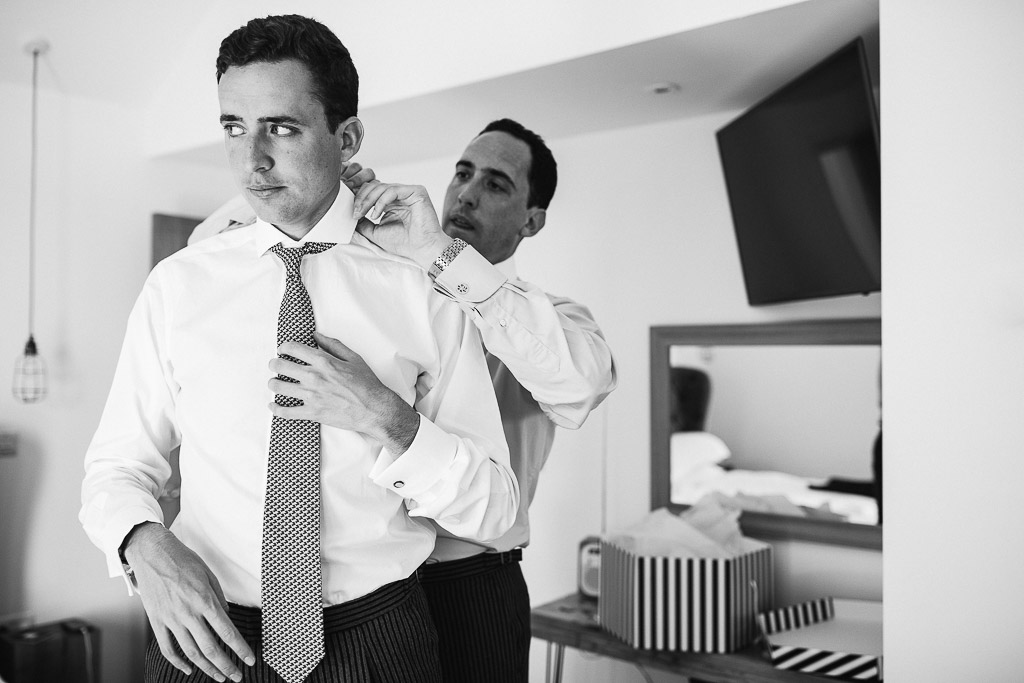 groom adjusting tie getting ready