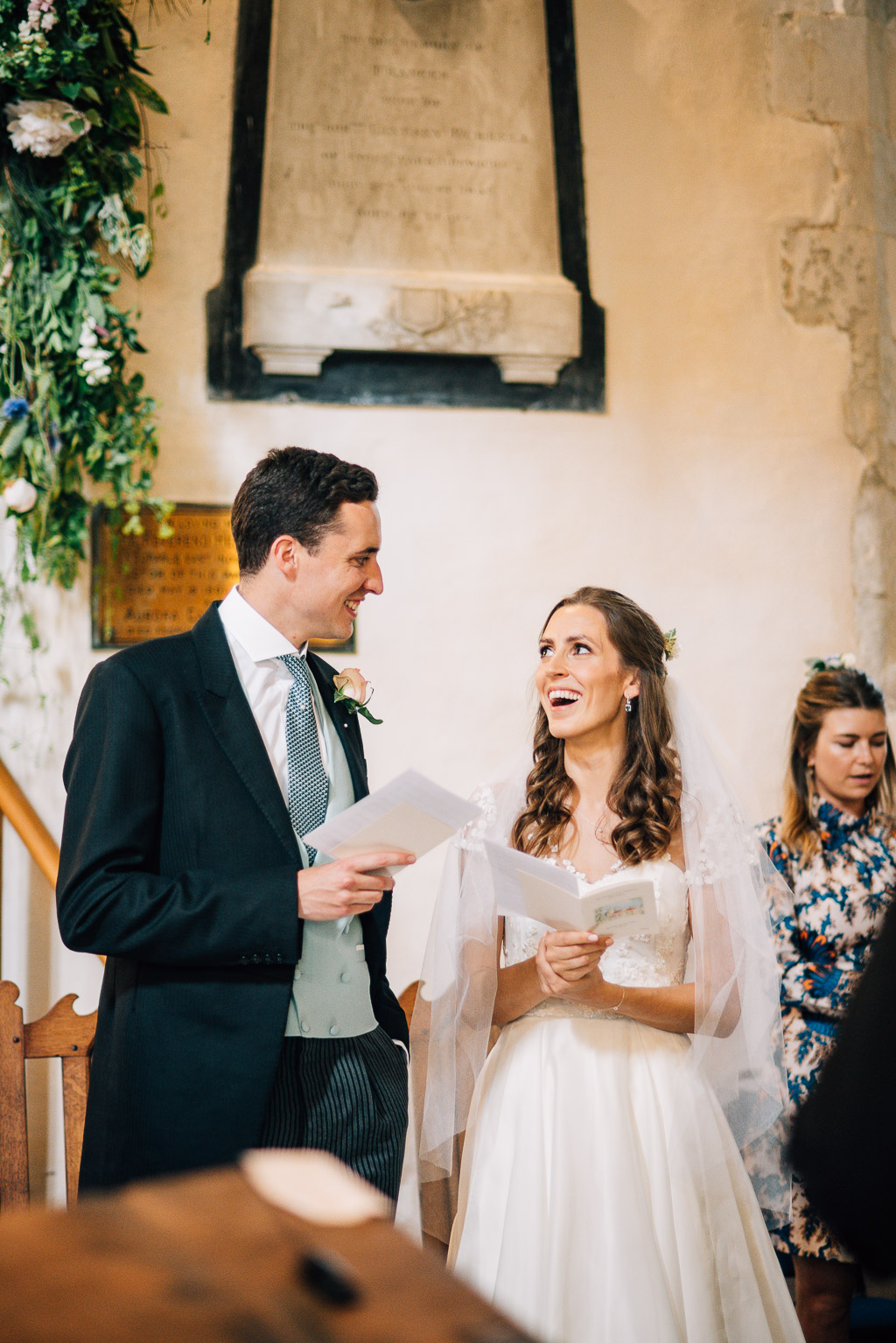 bride and groom smiling at each other in church