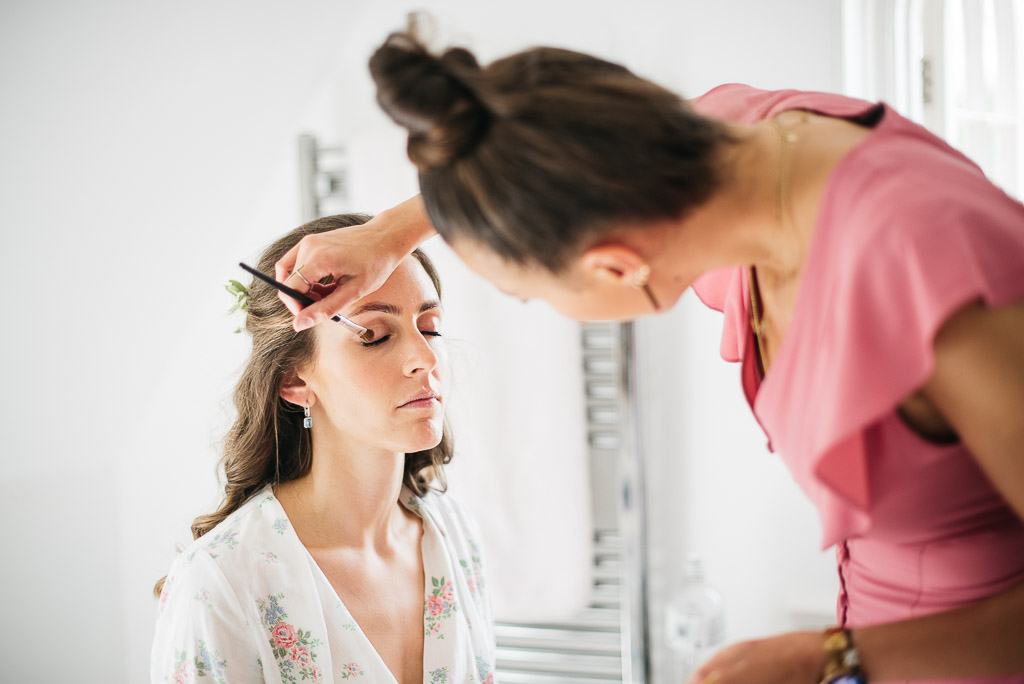bridal make-up artist doing make-up on bride