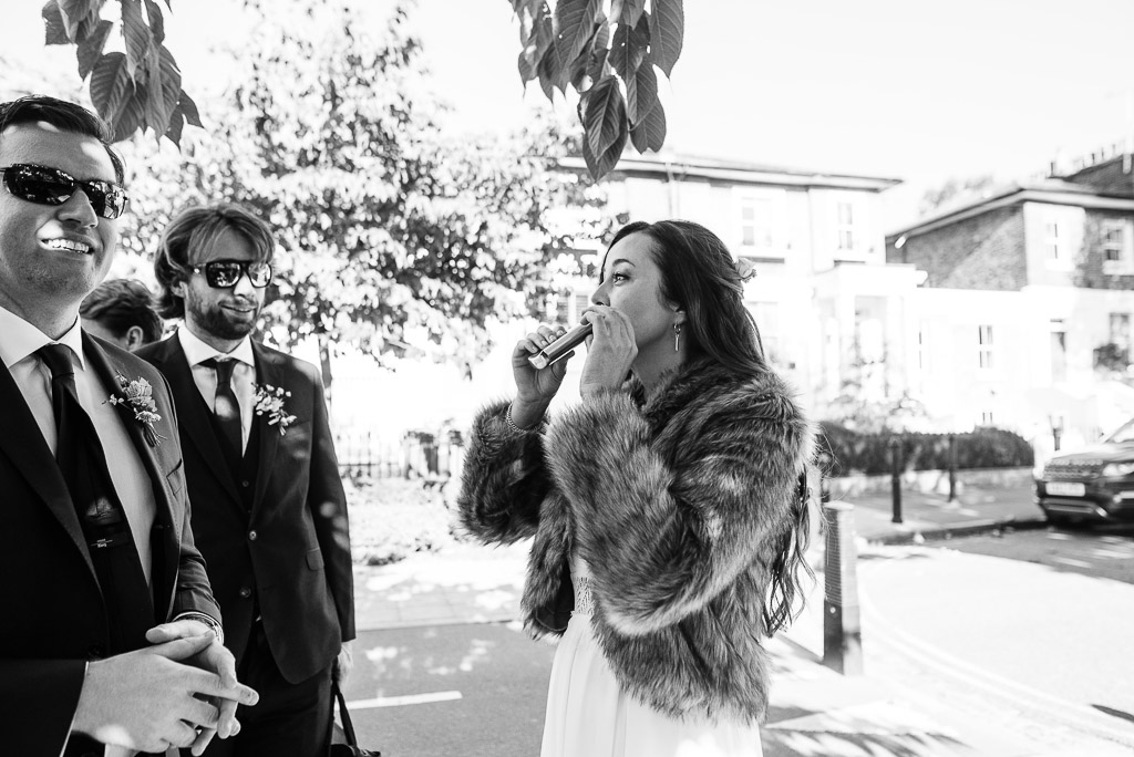 bride in fur coat drinking from hip flask
