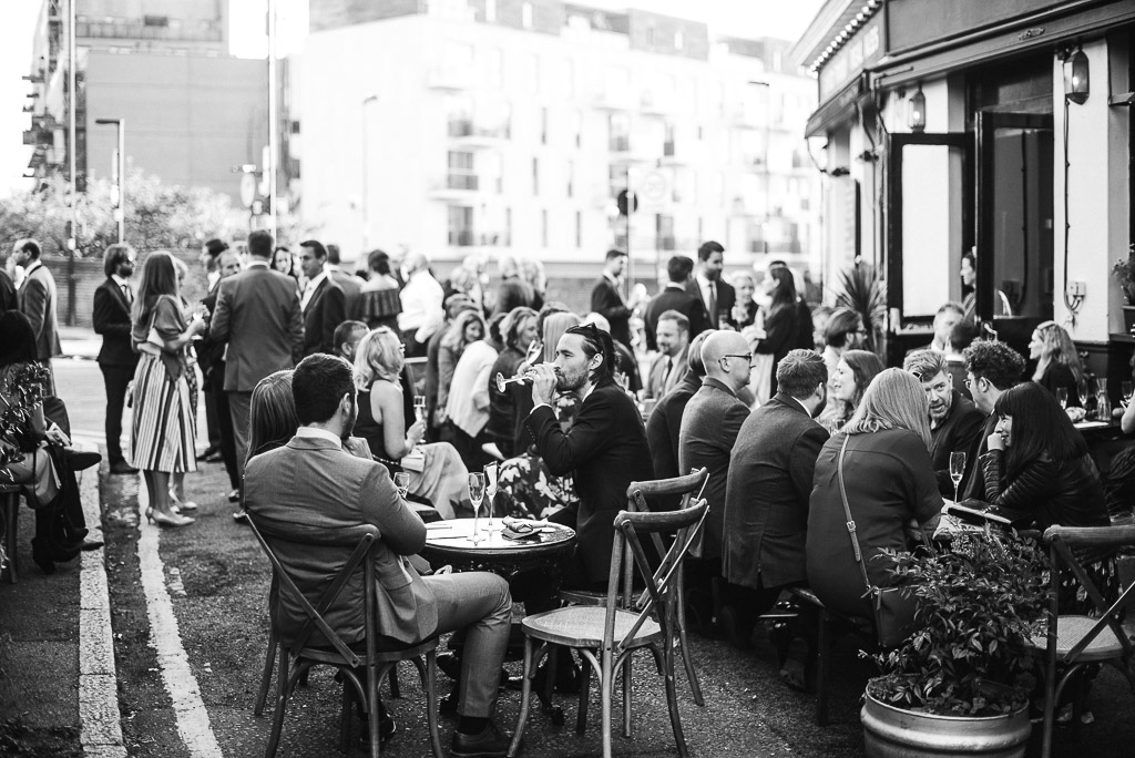 wedding guests sat outside pub wedding in london rosemary branch pub