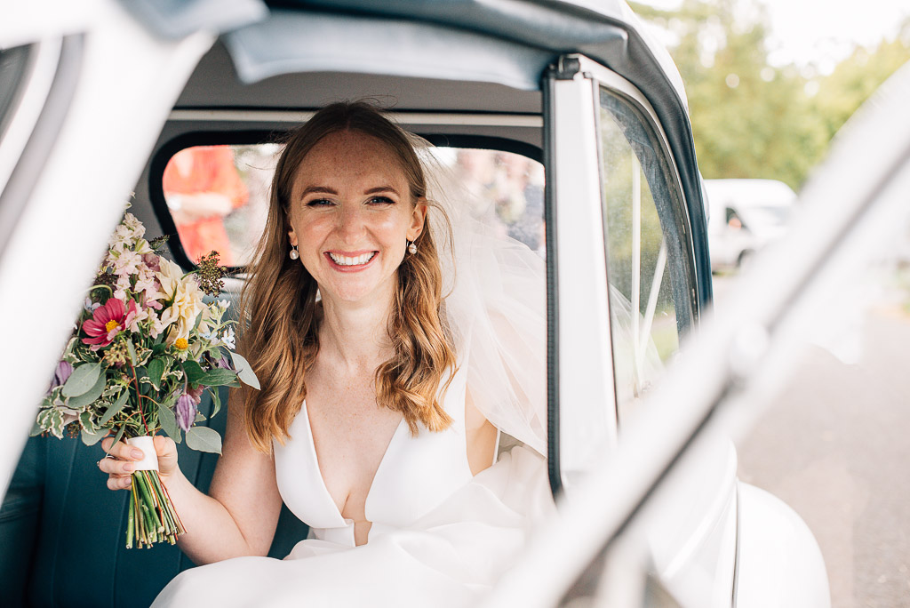 bride smiling in wedding car